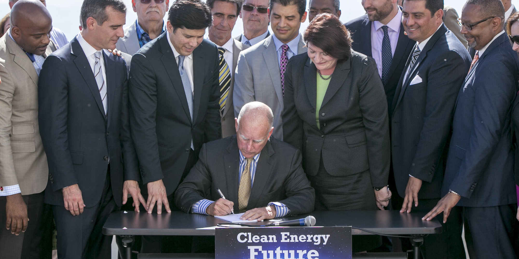California Gov. Jerry Brown, sitting center, surrounded by government officials, signs landmark legislation, bill SB350 by Senate President pro Tempore Kevin De Leon, third from left, to combat climate change by increasing the state's renewable electricity use to 50 percent and doubling energy efficiency in existing buildings by 2030 at a ceremony at the Griffith Observatory in Los Angeles on Wednesday, Oct. 7, 2015. (AP Photo/Damian Dovarganes)